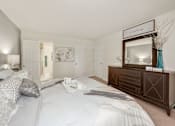 Thumbnail 13 of 32 - A bedroom with a large bed and a wooden dresser.