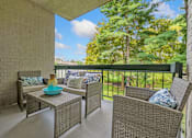 Thumbnail 25 of 32 - A patio with a table and chairs with a view of trees.