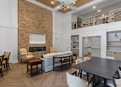 Thumbnail 12 of 42 - A modern living room with a brick wall and a fireplace.