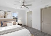Thumbnail 5 of 42 - A bedroom with a large bed and a ceiling fan.