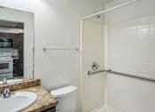 Thumbnail 4 of 14 - A bathroom with a white toilet, sink, and shower.