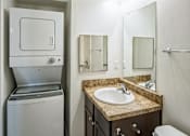 Thumbnail 3 of 14 - A bathroom with a sink, mirror, and toilet.