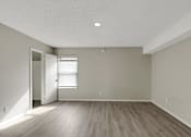 Thumbnail 10 of 13 - A room with a wooden floor and a door leading to another room.