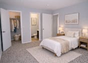 Thumbnail 2 of 22 - A bedroom with a bed, nightstands, and a closet.