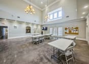 Thumbnail 5 of 8 - A room with tables and chairs and a white table in the middle.