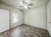 Thumbnail 2 of 8 - A room with a ceiling fan and a window with blinds.