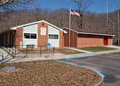 Thumbnail 2 of 2 - a brick school building with an flag in front of it