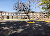 Thumbnail 12 of 12 - the front of a brick building with a tree in front of it