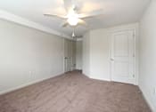 Thumbnail 4 of 30 - an empty living room with a ceiling fan and white walls