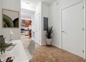 Thumbnail 9 of 13 - a room with a desk and a door to a kitchen and a living room
