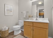 Thumbnail 15 of 17 - A white toilet sits next to a white sink in a bathroom.