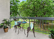 Thumbnail 24 of 32 - A patio with a table and chairs overlooking a green area.