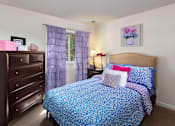 Thumbnail 20 of 32 - A bedroom with a blue patterned bedspread and matching curtains.