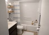 Thumbnail 4 of 22 - A white bathroom with a toilet, sink, and bathtub.