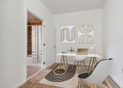 Thumbnail 10 of 13 - a home office with a desk and chair and a door to a bathroom