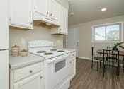 Thumbnail 4 of 12 - A kitchen with white appliances and cabinets.