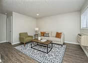 Thumbnail 3 of 12 - A living room with a couch, chair, and coffee table.