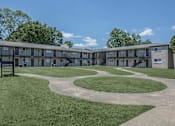 Thumbnail 10 of 12 - A large grassy area in front of apartment buildings.