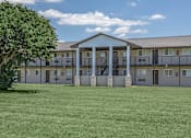 Thumbnail 7 of 12 - A large building with a tree in front of it.