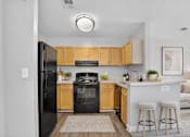 Thumbnail 11 of 17 - A kitchen with black appliances and wooden cabinets.