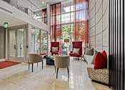 Thumbnail 2 of 13 - a lobby of a building with chairs and couches