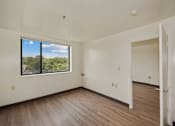 Thumbnail 5 of 10 - an empty living room with wood floors and a large window