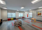 Thumbnail 14 of 20 - a play room with a couch and chairs and a table