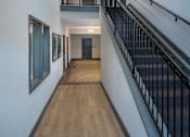 Thumbnail 13 of 20 - a long hallway with a staircase and a light hanging from the ceiling