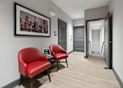 Thumbnail 18 of 20 - a corridor with two red chairs and a table in a hotel room