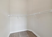 Thumbnail 12 of 20 - an empty closet with white walls and a wood floor