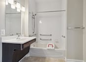 Thumbnail 11 of 20 - a bathroom with a tub and a sink and a mirror