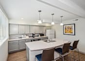 Thumbnail 22 of 30 - a kitchen with a large island and a white counter top