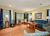 Thumbnail 3 of 24 - a living room with a blue couch and a table