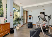 Thumbnail 23 of 24 - a gym with a treadmill and exercise equipment in the corner