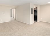 Thumbnail 10 of 20 - an empty living room with a door to a hallway and a closet