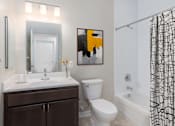 Thumbnail 5 of 20 - a bathroom with a toilet sink and shower and a mirror