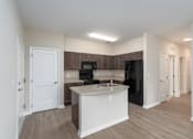 Thumbnail 6 of 20 - a kitchen with an island and a black refrigerator