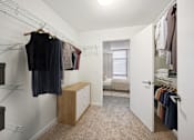 Thumbnail 12 of 13 - a walk in closet with clothes hanging on a rack and a door to a bedroom