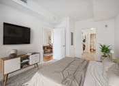 Thumbnail 4 of 13 - a bedroom with a large bed and a tv on the wall