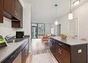 Thumbnail 5 of 13 - an open kitchen with a large island and a living room with a couch