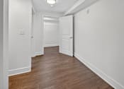 Thumbnail 10 of 20 - A long hallway with a white door at the end.
