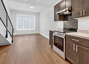Thumbnail 11 of 20 - A kitchen with a stainless steel oven and wooden cabinets.