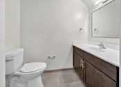 Thumbnail 18 of 20 - A white toilet sits next to a sink in a bathroom.
