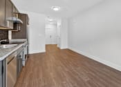 Thumbnail 15 of 20 - A kitchen with wooden floors and stainless steel appliances.