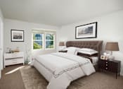 Thumbnail 4 of 13 - A bedroom with a large bed and a window overlooking a blue house.