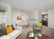 Thumbnail 2 of 13 - A living room with a white couch, a coffee table, and a dining table.