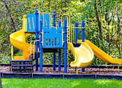 Thumbnail 11 of 13 - A playground with a blue and yellow slide.