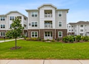 Thumbnail 19 of 19 - A large apartment complex with a well-maintained lawn in front.