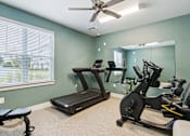 Thumbnail 11 of 19 - A room with a treadmill, exercise bike, and mirror.
