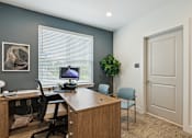 Thumbnail 10 of 19 - A room with a desk, chair, and computer.